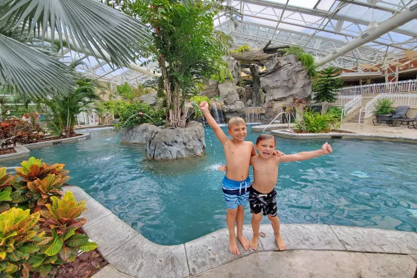 Two boys with their arms around eachother standing outside Biosphere pool.