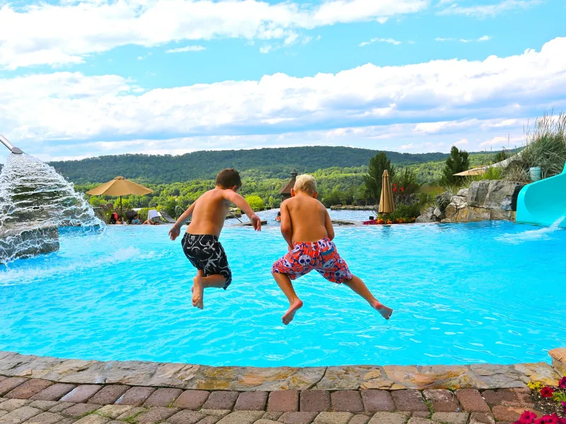 Two children jumping into vista 180 pool.
