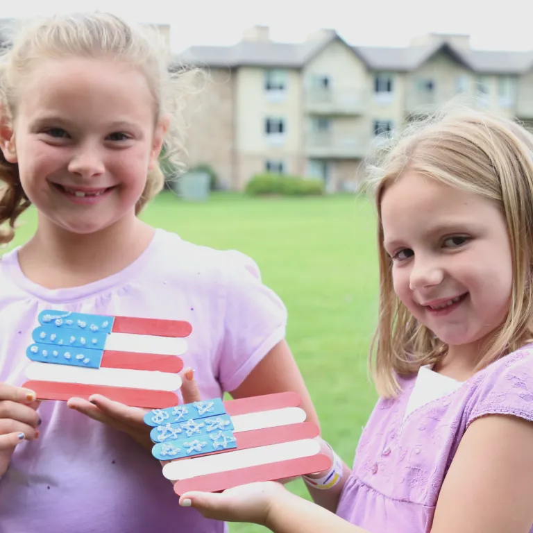 Two girls holding a handmade american flag craft