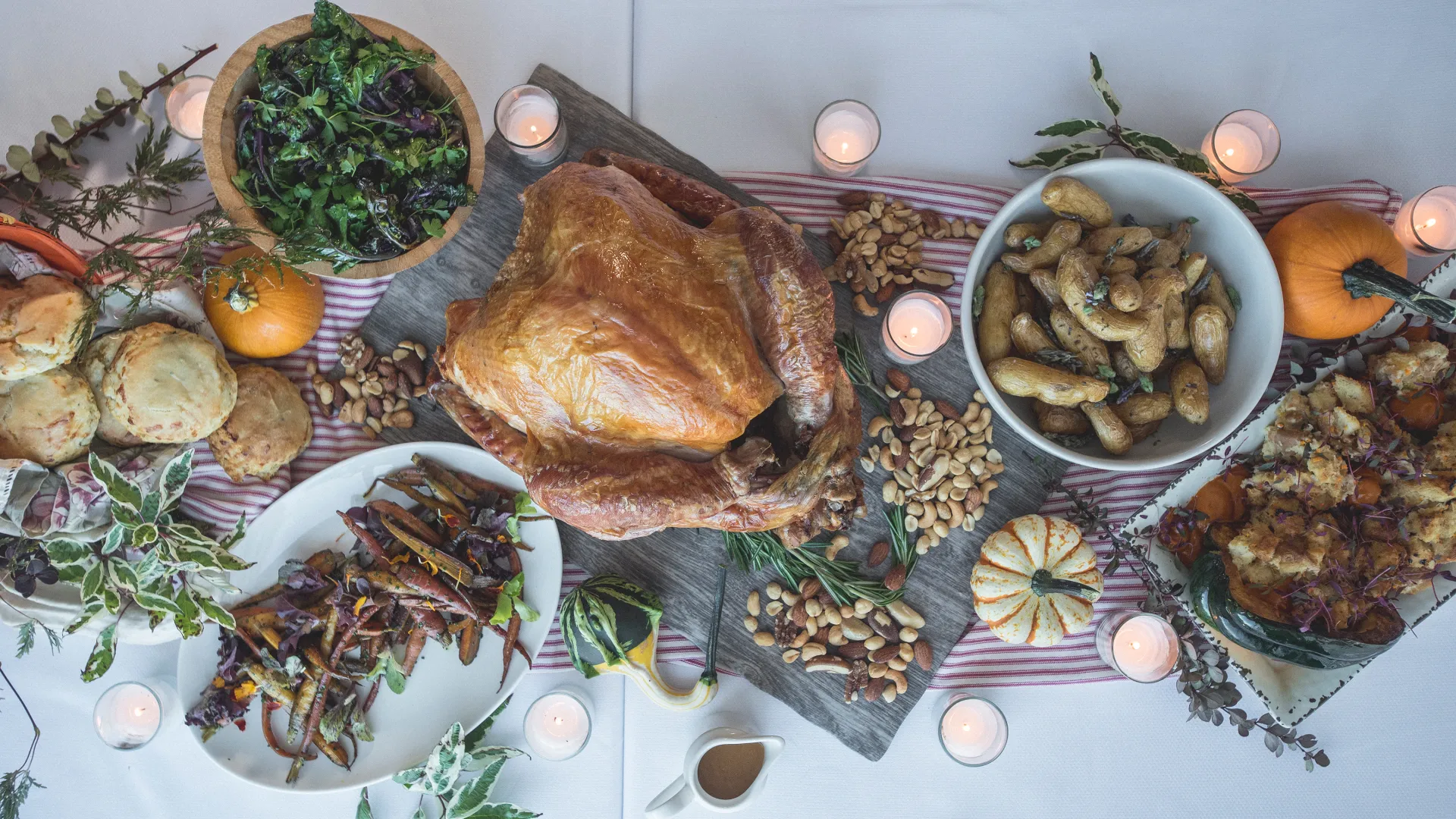 Table with spread of Thanksgiving food and candles 