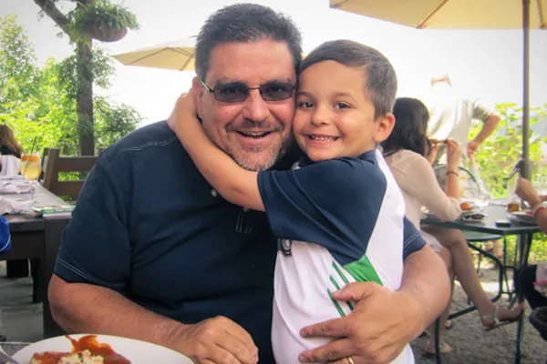 Young child hugging man.