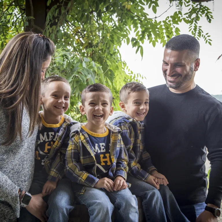 Woman, man, and three children laughing.