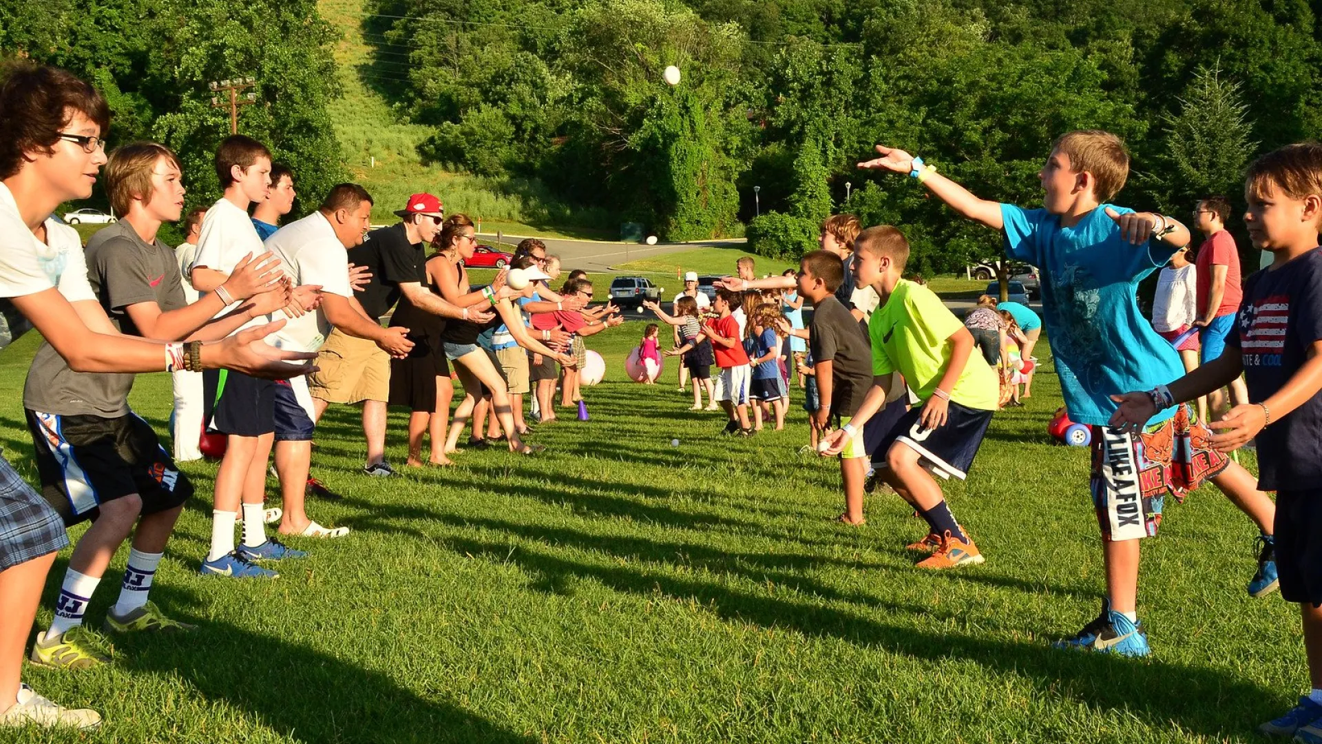 Rows of people playing the egg toss at the Memorial Day BBQ