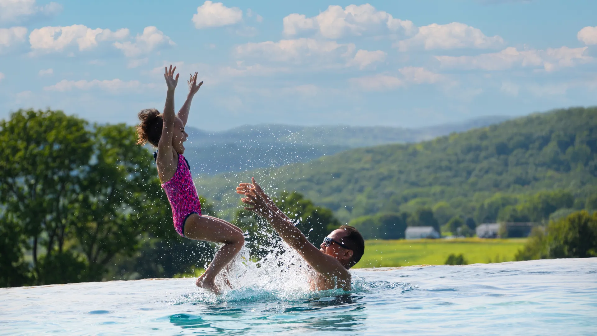 Man throws child in air in Vista pool.