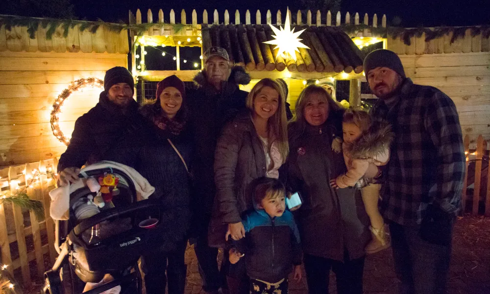 Family posing for camera with a Christmas star behind them.